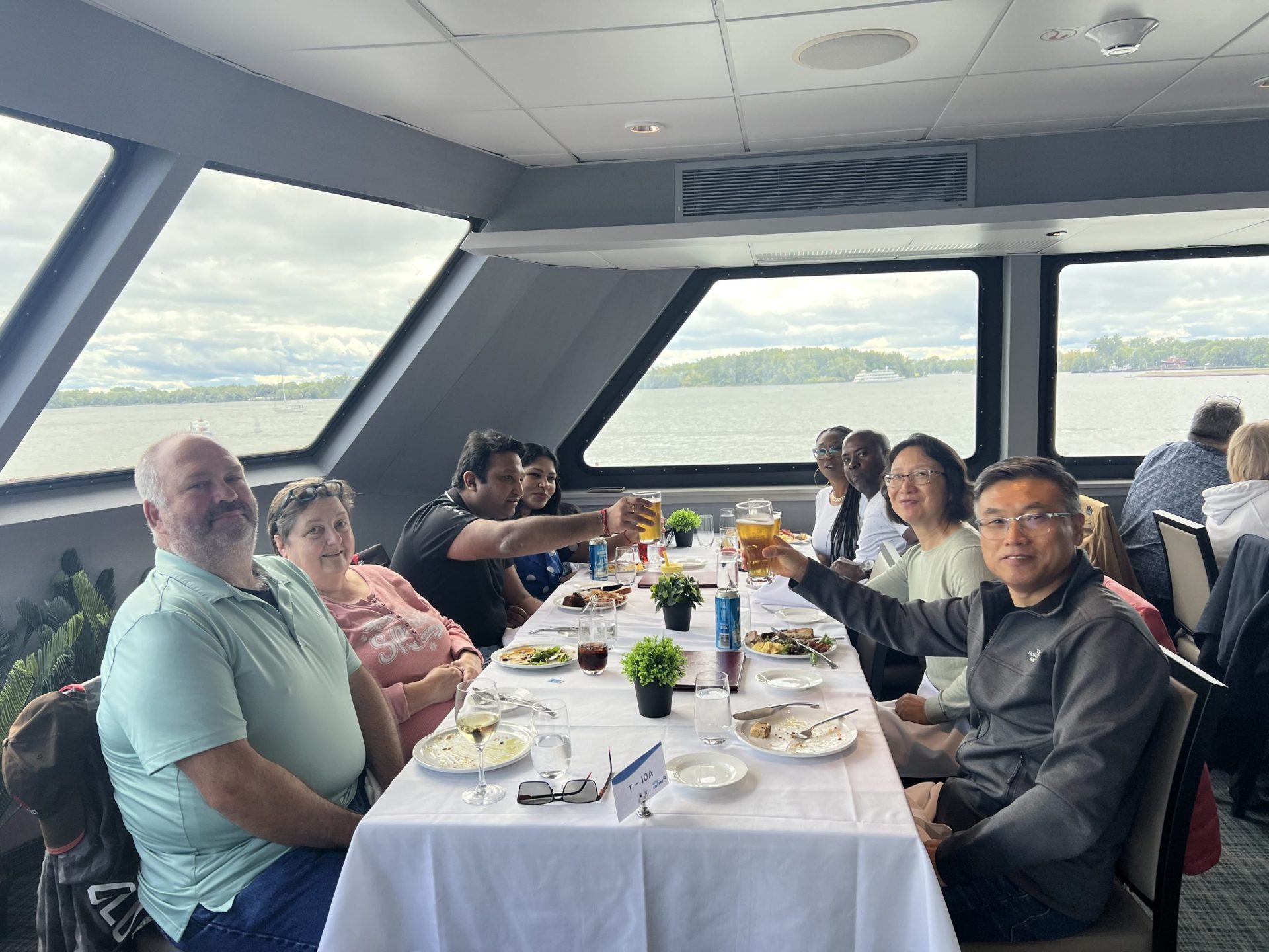 a group of people sitting at a table with food and drinks